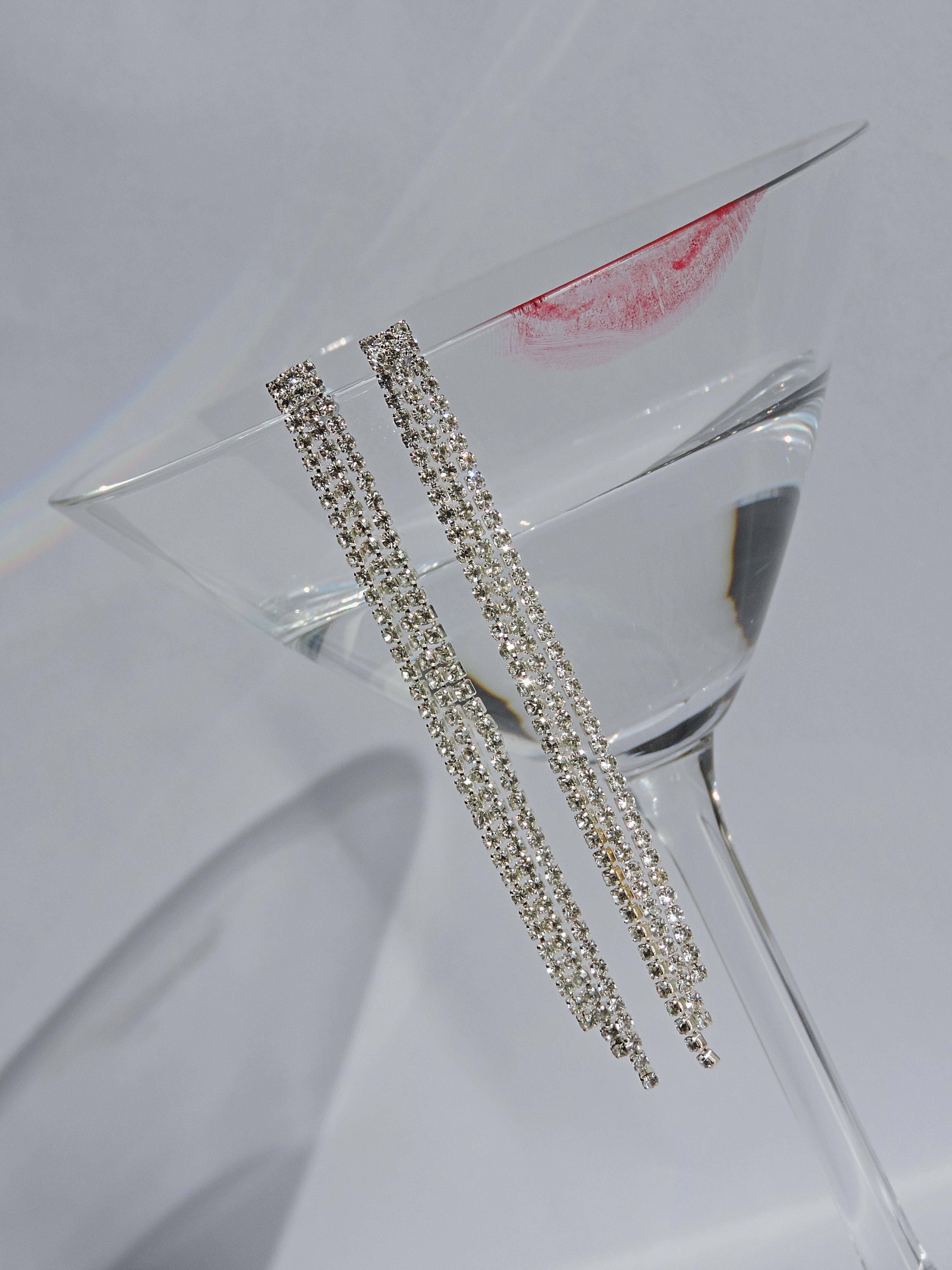 Pendientes largos de strass sobre una superficie de cristal